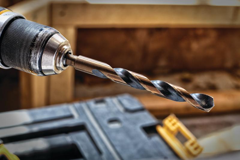 Close-up image of a drill with a metal twist drill bit attached, suitable for woodworking or construction tasks.